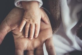 adult hand with baby hand