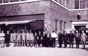 3. Kaukauna postal employees standing in front of post office located in the municipal building in 1923. L to R: Adolf Mills, postmaster and Fritz Milz, assistant postmaster; mail carriers August Carnot, Art Schubring, Carl Swedberg, Harry Treptow and Alphonse Berens; clerks, Genevieve DeBrue, Flora Seifert and Owen Kitto; rural carriers, John Kobussen, Mr. Ruppert, Ted Smits, John Brouchek and John Van Dyke; Carl Anderson, who hauled mail from the trains; and Melvin Trams, special delivery carrier.