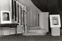 View of interior of Pechman Studio showing staircase and two portraits. 1955